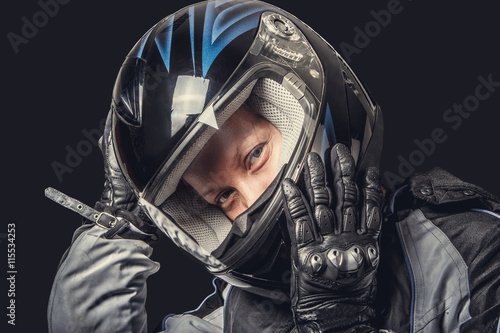 Female in motorcycle safety costume and black helmet. © Fxquadro