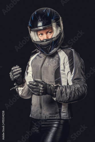 Female in motorcycle safety costume and black helmet.