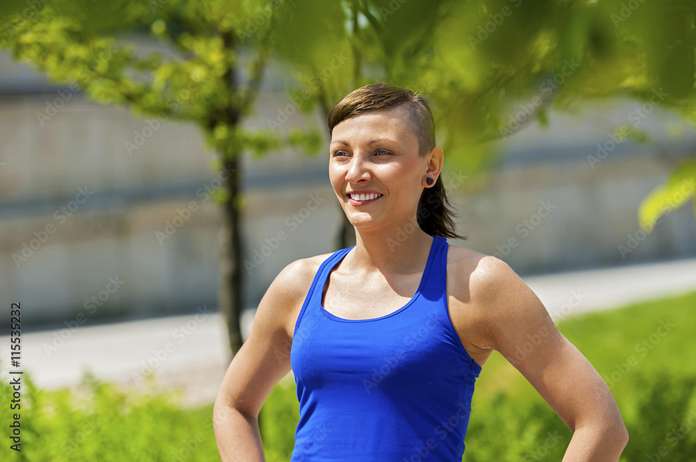 Woman jogger resting after run in city park.