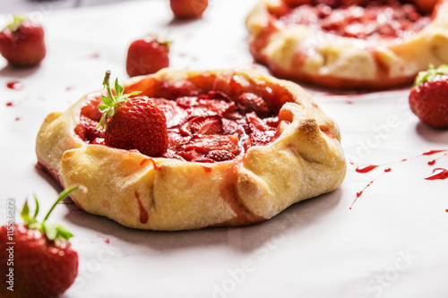 Rustic Tarts with strawberries on a white paper for baking 