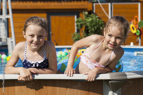 Two sisters in bikini swimming pool