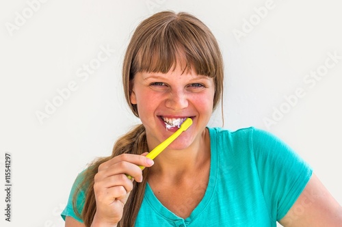 Young lady brushing teeth in the morning