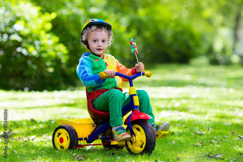 Little boy on colorful tricycle photo