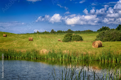 haystacks on the field with a pond in Poland