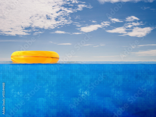 pool side view with yellow swim ring on blue sky background