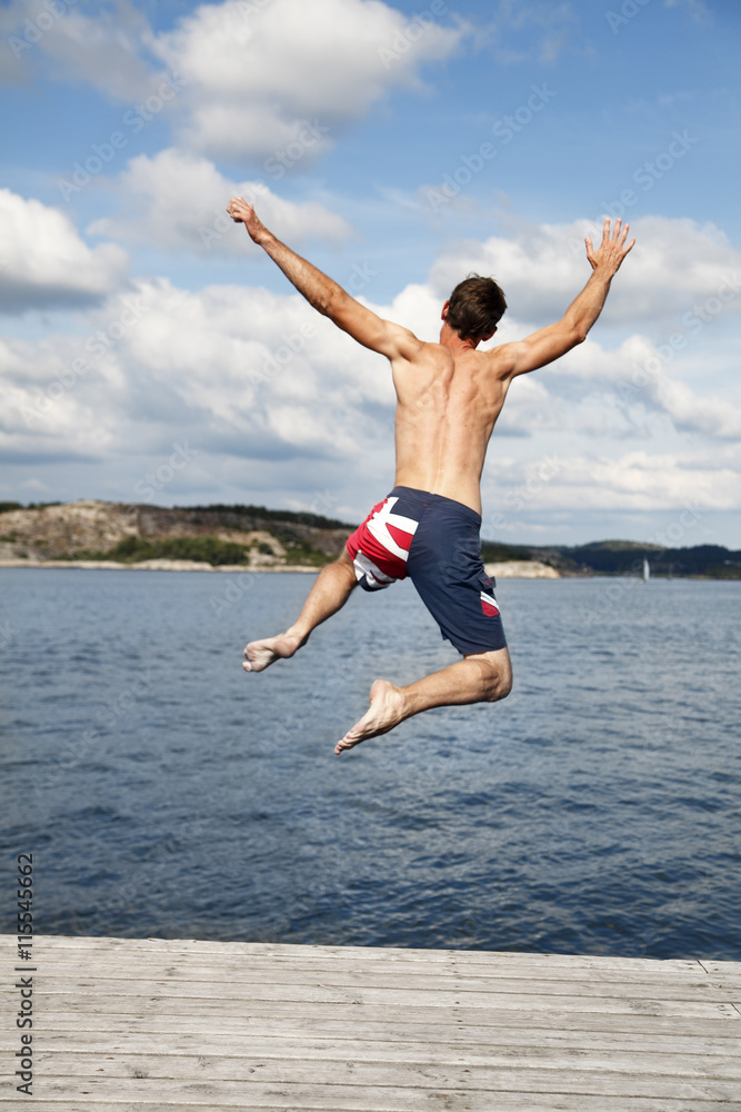 Sweden, Bohuslan, Tjorn, Rear view of man jumping into water Sweden, Bohuslan, Tjorn, Rear view of man jumping into water