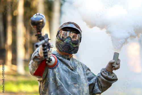 Cool guy with paintball gun and smoke grenade