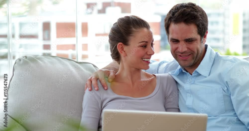 Couple relaxing on the couch using laptop Couple relaxing on the couch using laptop
