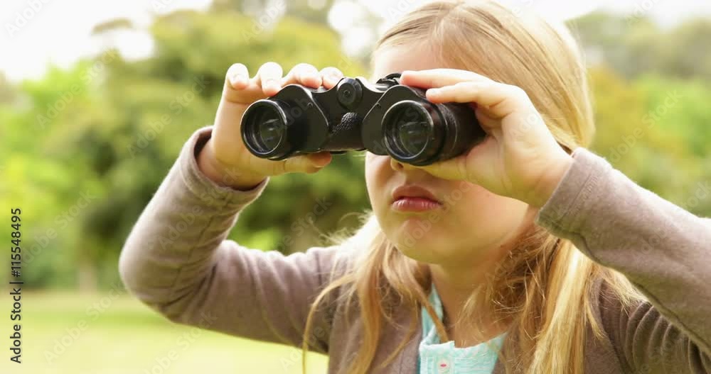 Cute little girl using binoculars in park Cute little girl using binoculars in park