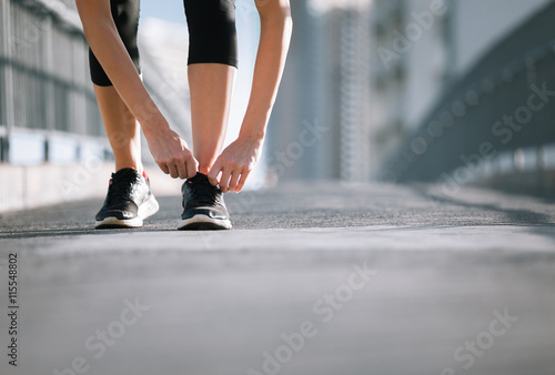 Getting ready for a run. Female runner tying her shoe.