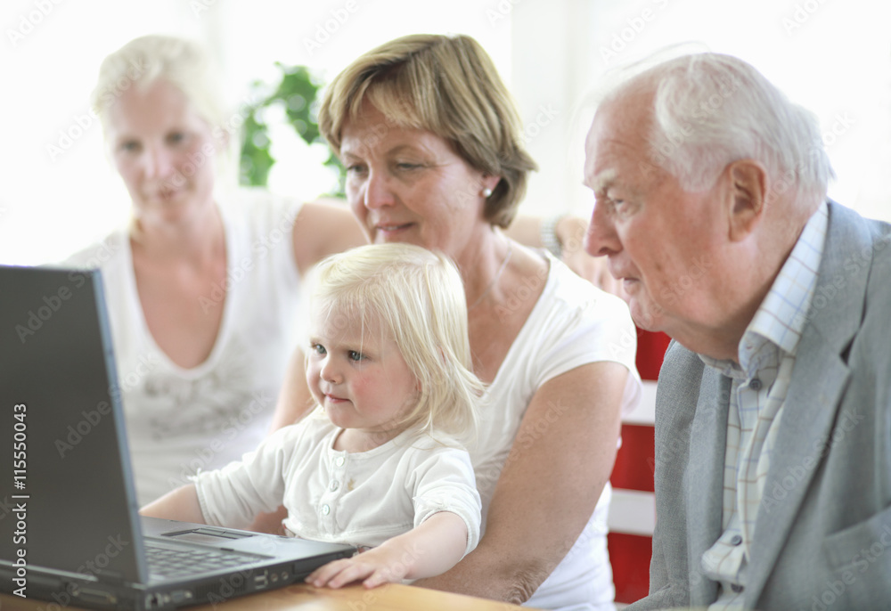 Multi generation family with girl (2-3) using laptop Multi generation family with girl (2-3) using laptop