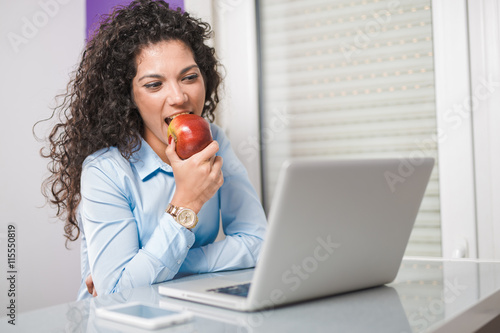 Business women eat fruit on work.