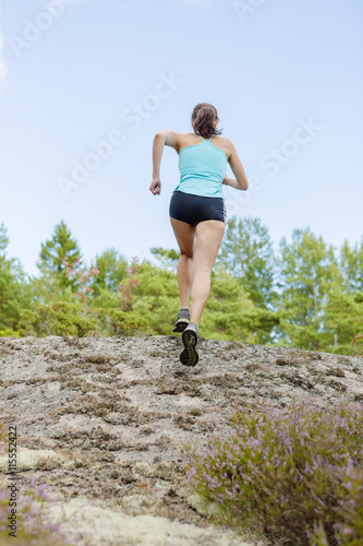 Sweden, Smaland, Mid adult woman running of road photo