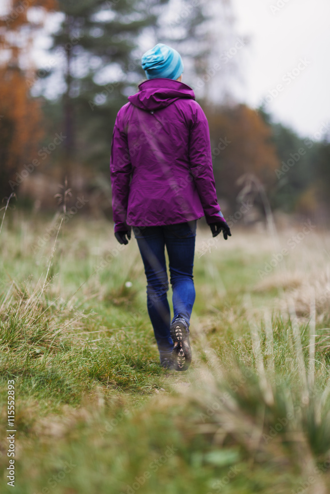 Sweden, Bohuslan, Tjorn, Rear view of mid adult woman walking through meadow Sweden, Bohuslan, Tjorn, Rear view of mid adult woman walking through meadow