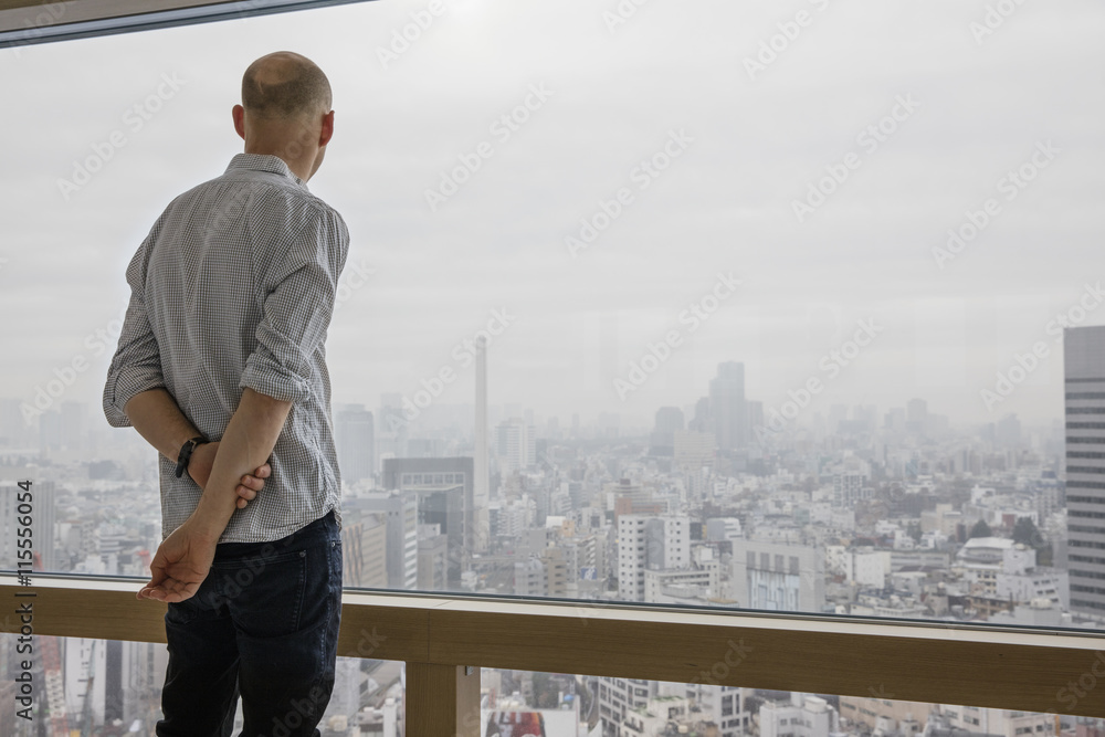 Japan, Tokyo, Shibuya, Man looking at cityscape through window Japan, Tokyo, Shibuya, Man looking at cityscape through window