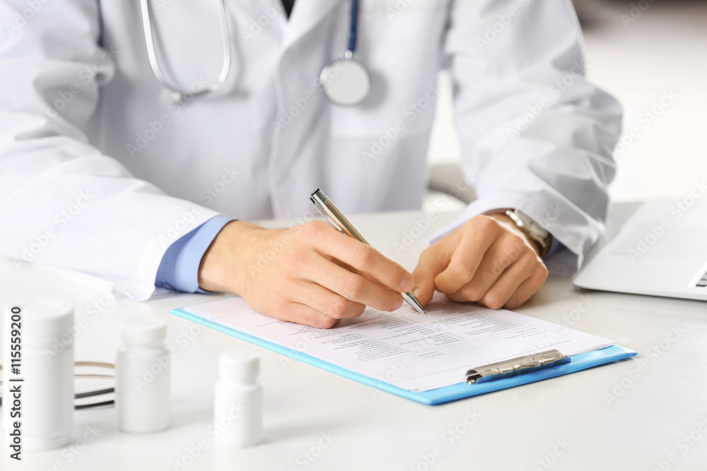 Doctor working at table in office