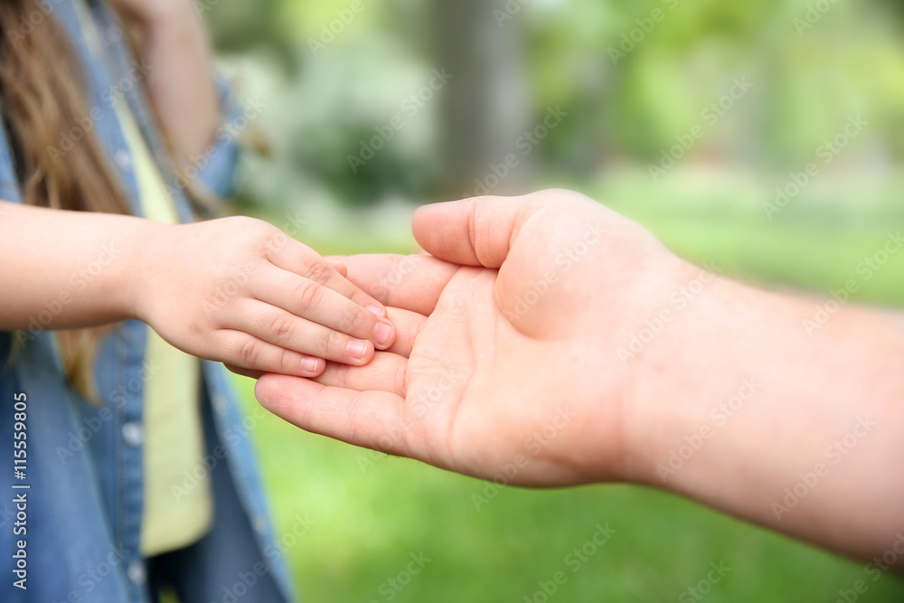 Adult and child hands on natural background