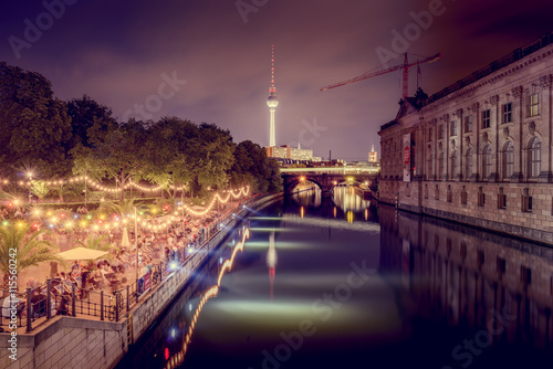 Germany, Berlin, Museum Island, Illuminated riverbank and reflections in water photo