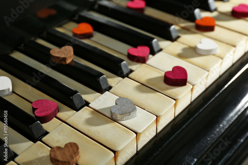 Colourful hearts on piano keys, close up