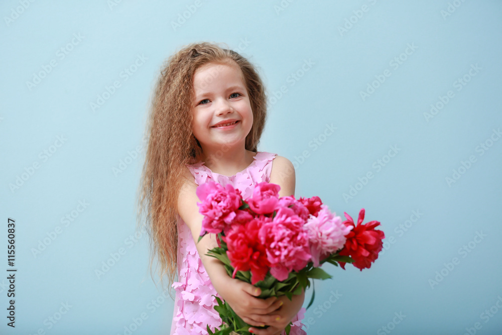 Girl holding fresh peonies bouquet on blue background