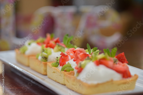 Tarts with whipped cream and strawberries and mint leaves