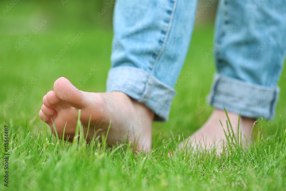 Woman walking barefoot on green grass background Woman walking barefoot on green grass background