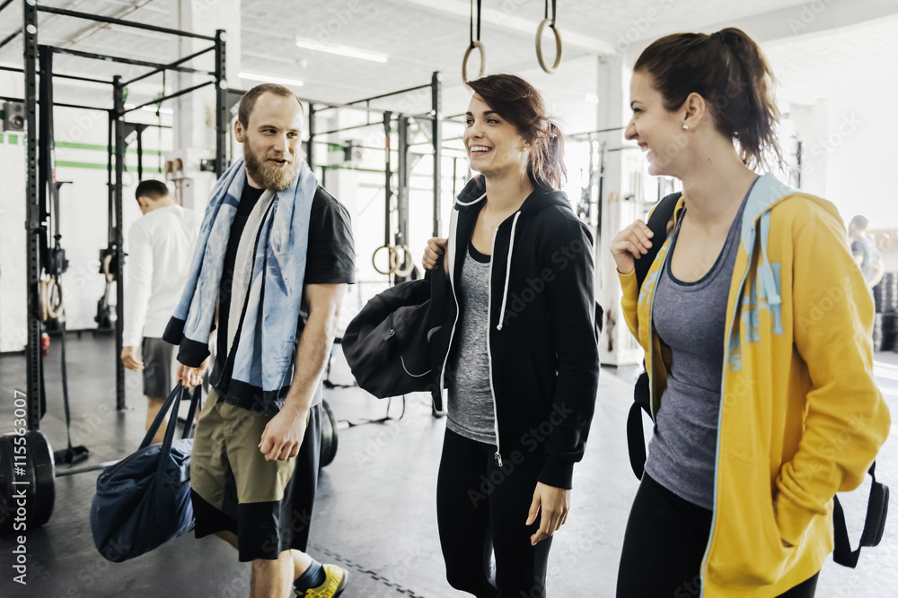Young women and man talking with each other in gym Young women and man talking with each other in gym