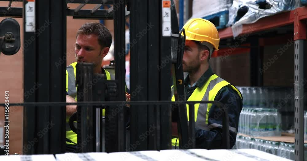Warehouse worker talking with forklift driver in 4k video format Warehouse worker talking with forklift driver in 4k video format