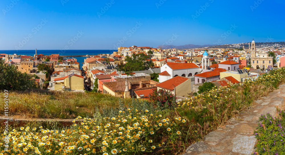 The medieval city with Orthodox cathedral Trimartiry and lighthouse in old harbour, panoramic aerial view from Schiavo Bastion in the sunny morning, Crete, Greece
