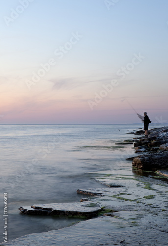 Sweden, Oland, Sandvik, Man fishing at sunset photo