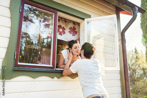 Sweden, Gastrikland, Sandviken, Couple kissing though window of house photo