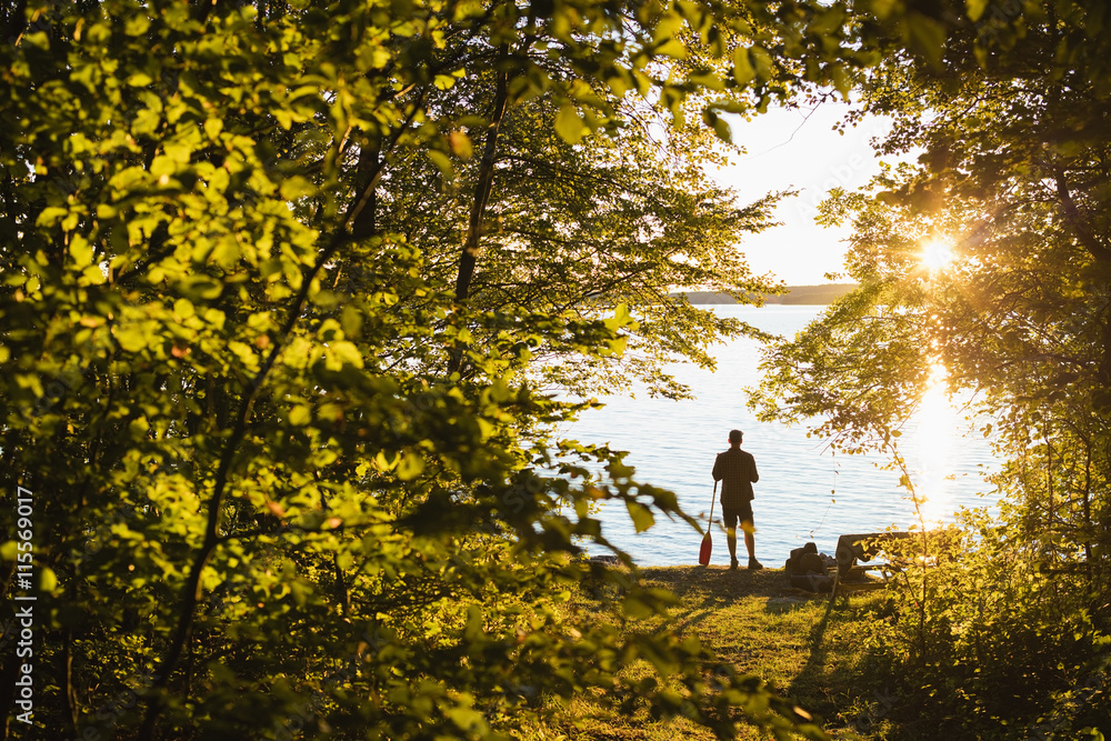 Sweden, Skane, Immeln, Silhouette of man standing with oar at sunset Sweden, Skane, Immeln, Silhouette of man standing with oar at sunset
