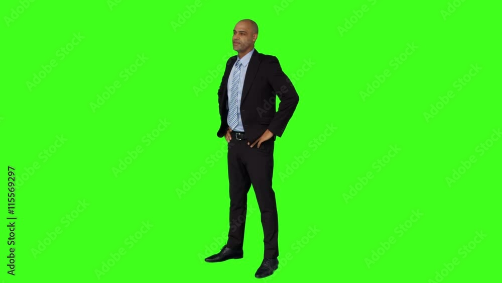 Businessman standing with hands on hips on green screen background Businessman standing with hands on hips on green screen background
