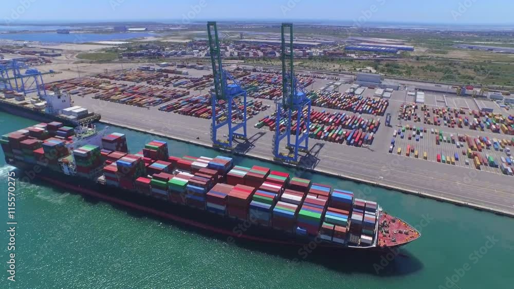 AERIAL: Fully loaded container ship docked at freight port terminal