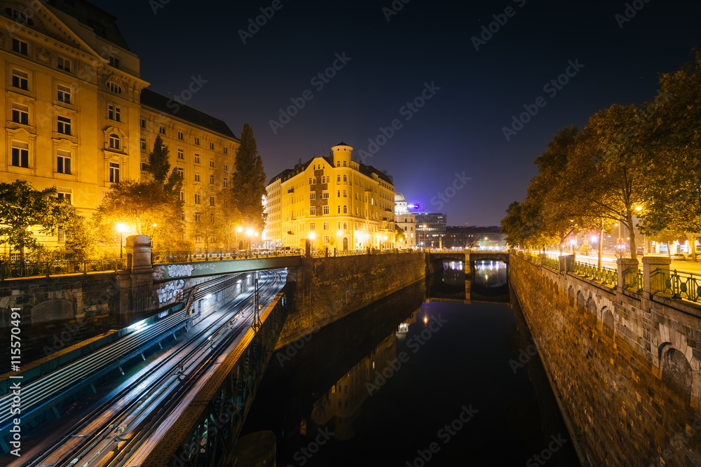 Buildings along and train bridge over Wienfluss at night, in Vie