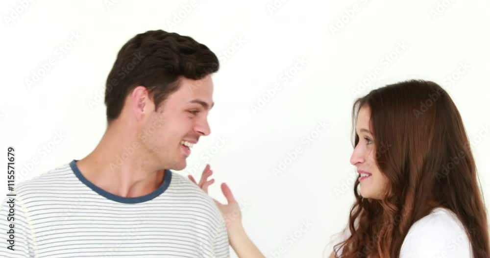 Smiling woman whispering something to boyfriend on white background Smiling woman whispering something to boyfriend on white background