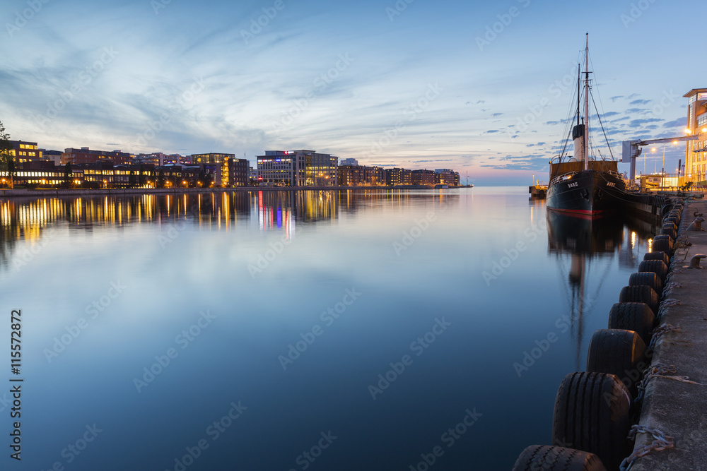 Sweden, Skane, Malmo, Moored ship and cityscape at dusk Sweden, Skane, Malmo, Moored ship and cityscape at dusk
