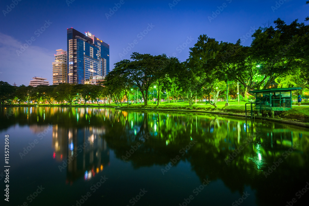 Lake and skyscrapers at night, at Lumphini Park, in Bangkok, Tha