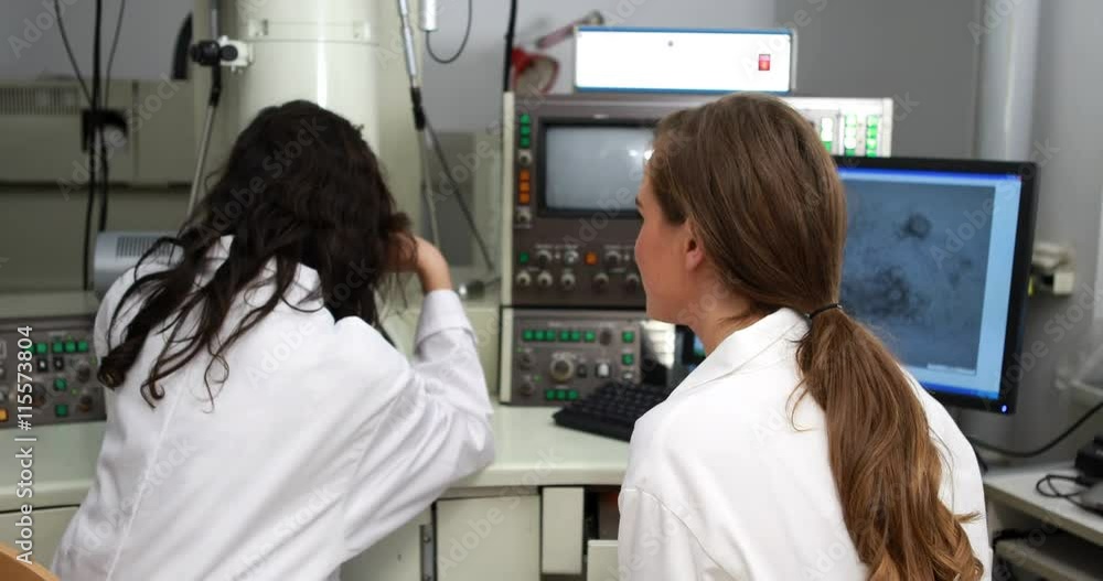 Young science students working together with microscope in high quality 4k format Young science students working together with microscope in high quality 4k format
