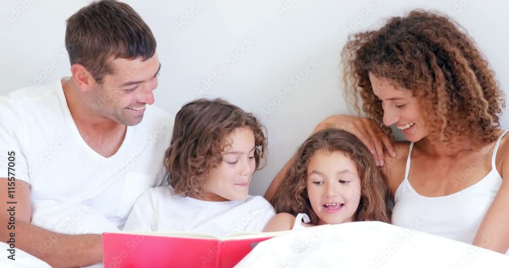 Focused parents reading tale to their children Focused parents reading tale to their children