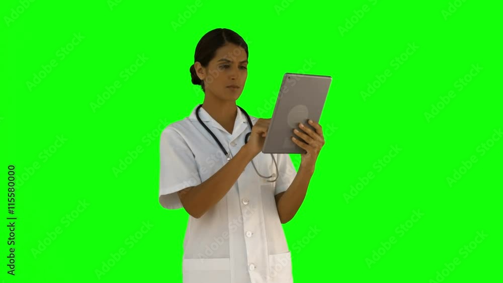 Nurse using her tablet pc on green screen background Nurse using her tablet pc on green screen background