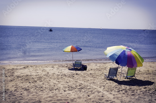 Beach umbrellas and chairs on a beach in Eastham, MA Cape Cod. © cindygoff