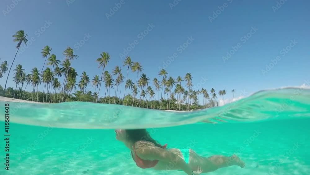 UNDERWATER: Happy young woman diving in fantastic tropical island lagoon UNDERWATER: Happy young woman diving in fantastic tropical island lagoon