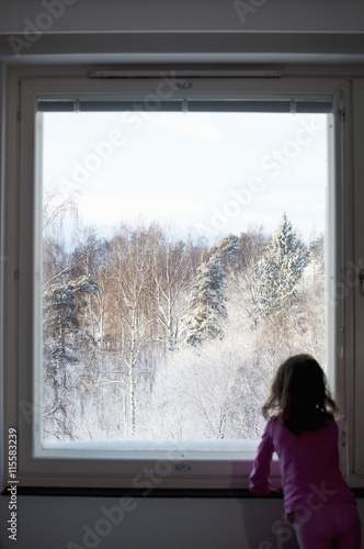 Finland, Uusimaa, Girl (4-5) looking through window photo