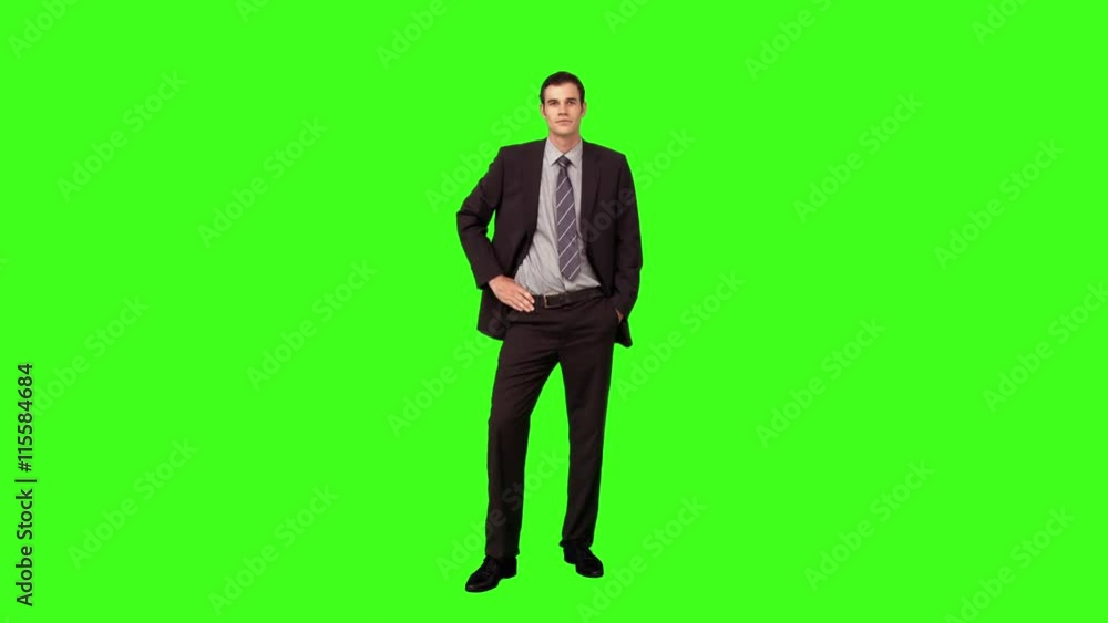 Businessman standing with hand on hip on green screen background Businessman standing with hand on hip on green screen background