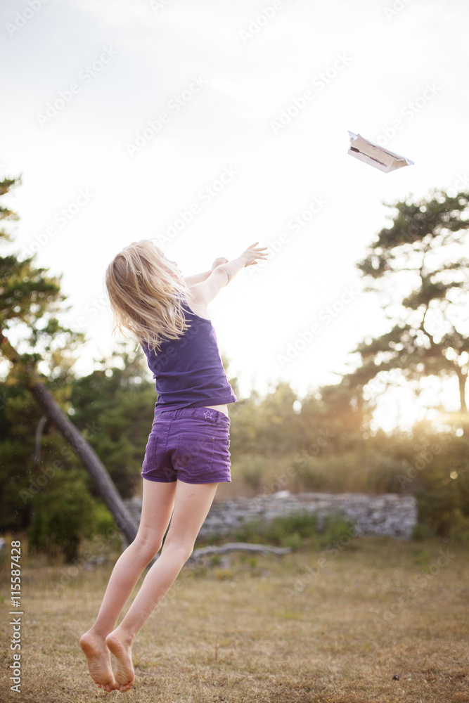 Sweden, Gotland, Faro, Girl (8-9) throwing paper airplane into air Sweden, Gotland, Faro, Girl (8-9) throwing paper airplane into air