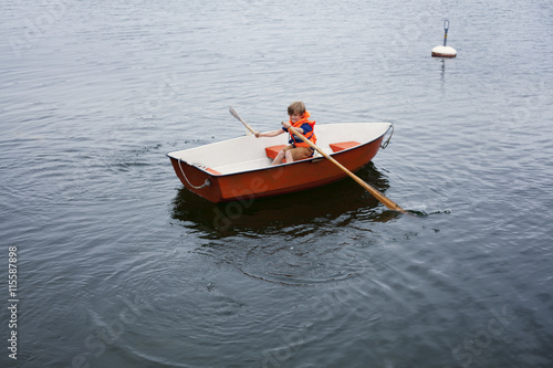 Sweden, Uppland, Runmaro, Barrskar, Boy (6-7) in rowboat photo