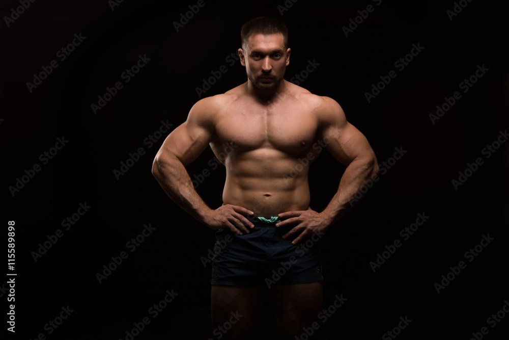 Fototapeta premium handsome muscular bodybuilder posing on a black background