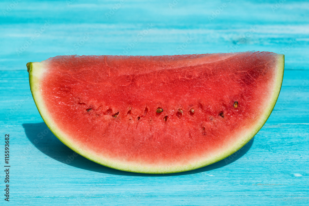Fresh slice of watermelon on blue wooden background Fresh slice of watermelon on blue wooden background