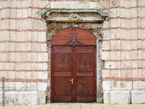 Wallpaper Mural Church door.  Entrance wooden door of the old Orthodox Church decorated with carvings on the background of stone facade wall Torontodigital.ca